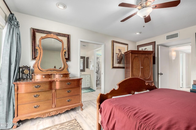 bedroom featuring ceiling fan, light wood-type flooring, and ensuite bath