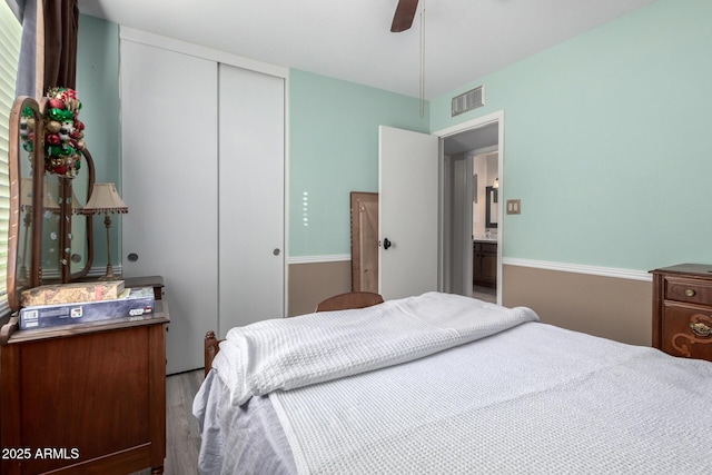 bedroom featuring hardwood / wood-style flooring, ceiling fan, and a closet