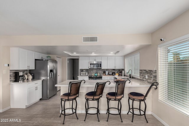 kitchen with white cabinetry, sink, a breakfast bar area, and appliances with stainless steel finishes