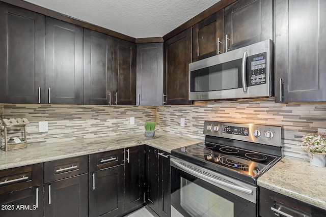 kitchen featuring appliances with stainless steel finishes, decorative backsplash, light stone counters, and dark brown cabinets