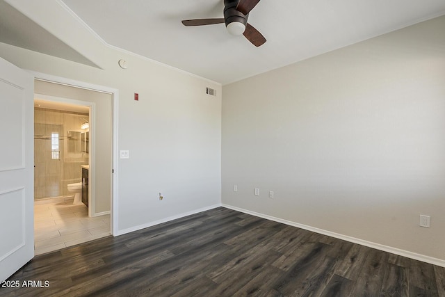 spare room with a ceiling fan, baseboards, visible vents, and dark wood-style floors