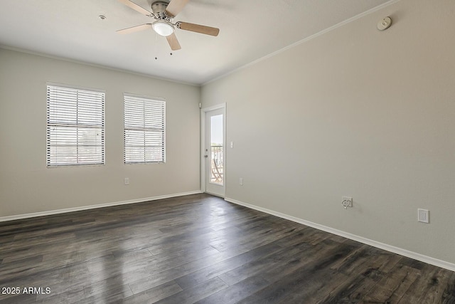empty room featuring baseboards, ornamental molding, a ceiling fan, and dark wood finished floors
