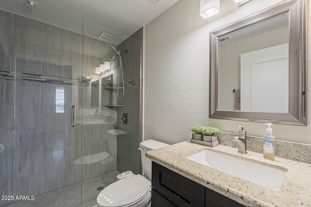 full bath featuring a textured wall, a stall shower, and toilet