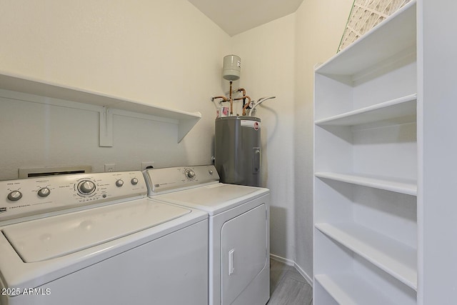 washroom with laundry area, washing machine and clothes dryer, wood finished floors, baseboards, and water heater