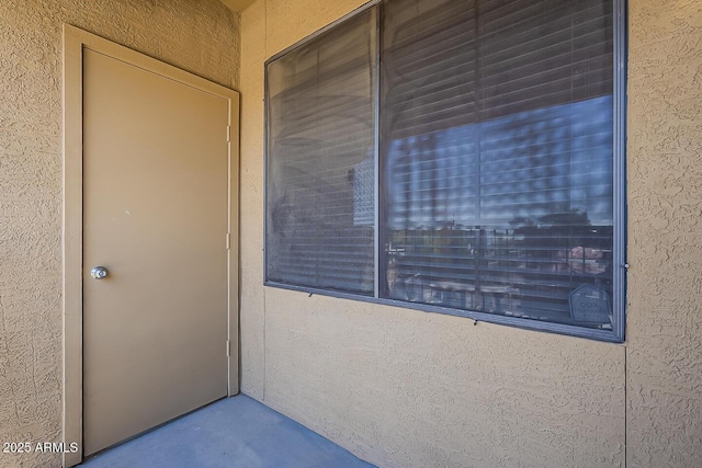 property entrance with stucco siding