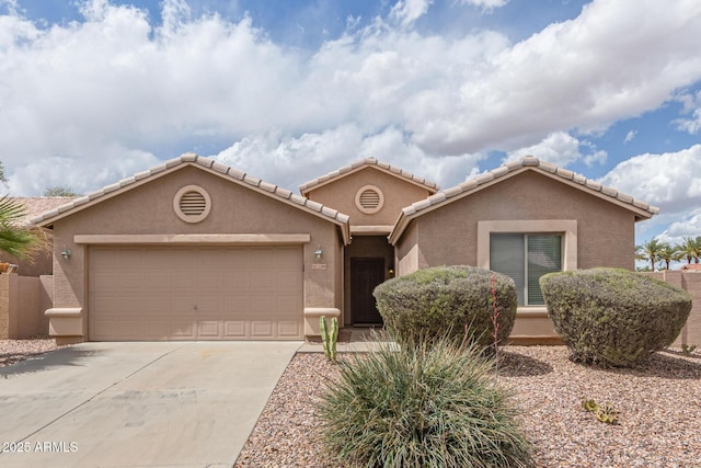 view of front of house with a tile roof, concrete driveway, stucco siding, and an attached garage
