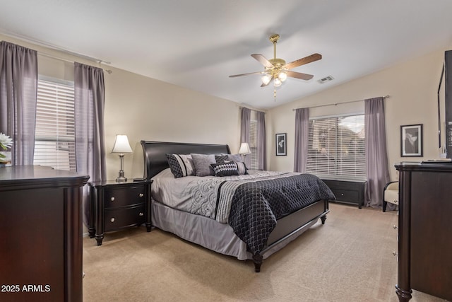 bedroom featuring light colored carpet, lofted ceiling, visible vents, and a ceiling fan