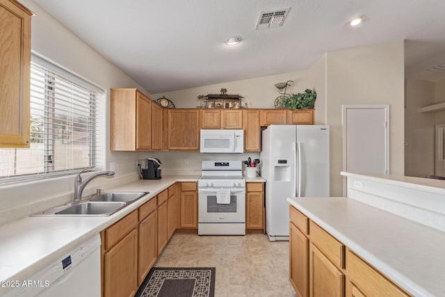 kitchen featuring light countertops, a sink, lofted ceiling, white appliances, and visible vents