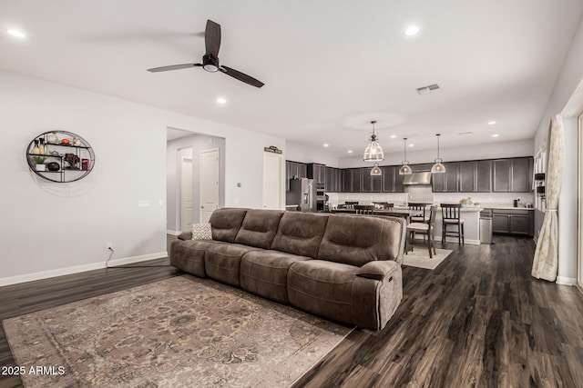 living room with visible vents, baseboards, recessed lighting, dark wood-style floors, and a ceiling fan