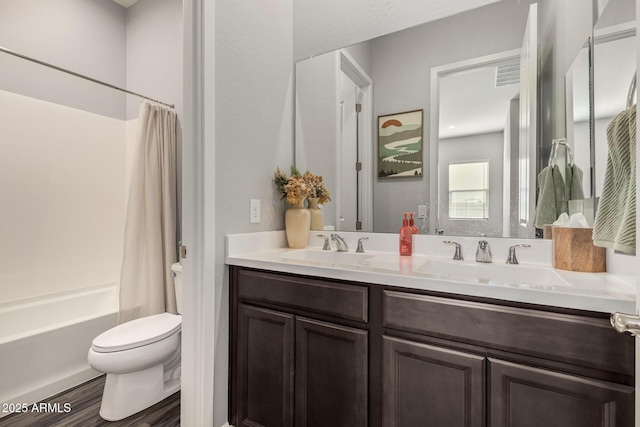 bathroom with double vanity, toilet, shower / bathtub combination with curtain, and a sink