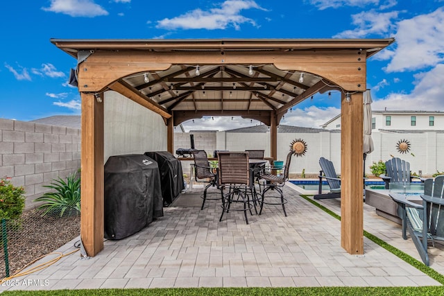 view of patio featuring a fenced in pool, a gazebo, outdoor dining area, a fenced backyard, and area for grilling