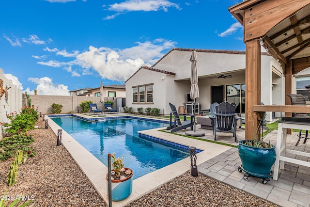 view of swimming pool with a patio, a fenced backyard, a fenced in pool, and ceiling fan