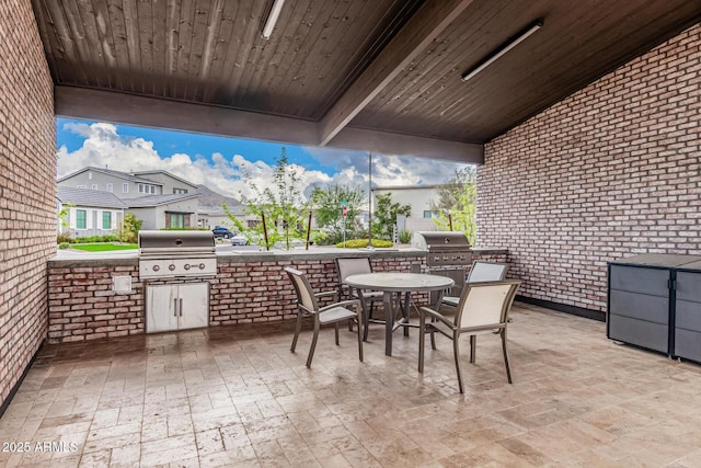 view of patio with outdoor dining space, an outdoor kitchen, and a grill