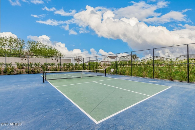 view of tennis court featuring fence