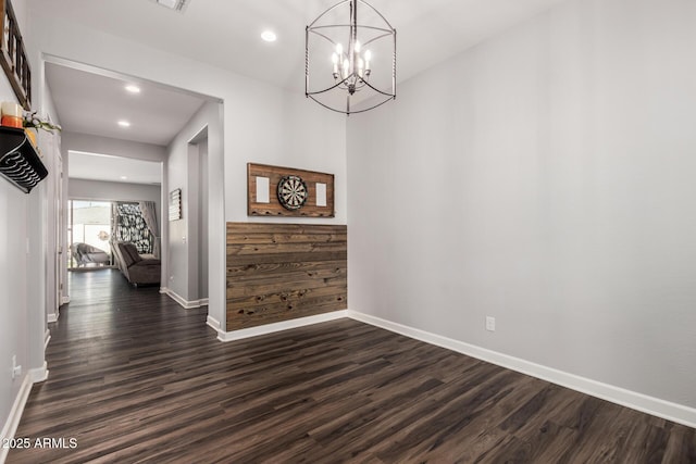 interior space featuring dark wood-type flooring, a notable chandelier, recessed lighting, and baseboards