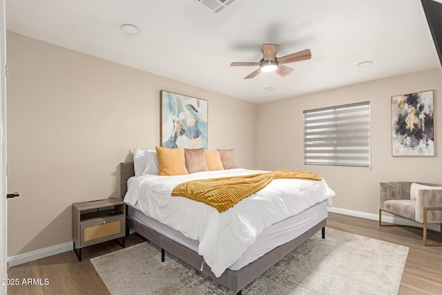 bedroom featuring baseboards, visible vents, wood finished floors, and ceiling fan