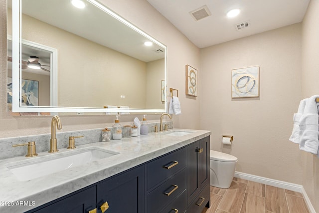 full bathroom with toilet, a sink, and visible vents