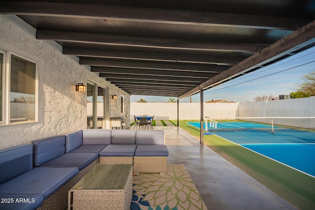 view of patio / terrace featuring fence private yard, an outdoor hangout area, a tennis court, and outdoor dining space
