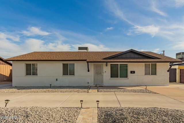 single story home featuring concrete driveway, stucco siding, and roof with shingles