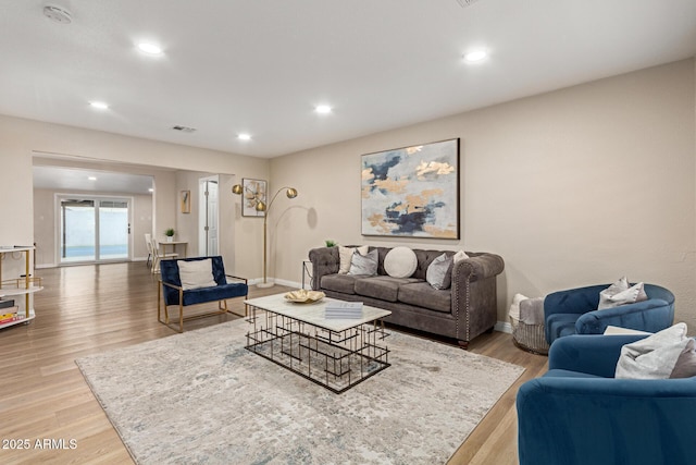 living room with baseboards, visible vents, wood finished floors, and recessed lighting