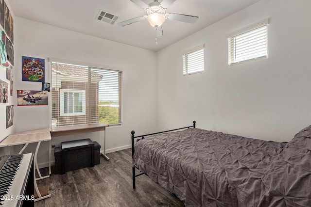 bedroom with visible vents, a ceiling fan, baseboards, and wood finished floors