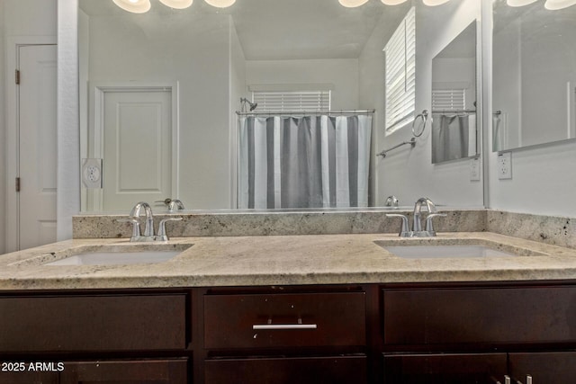 full bathroom featuring a shower with shower curtain, double vanity, and a sink