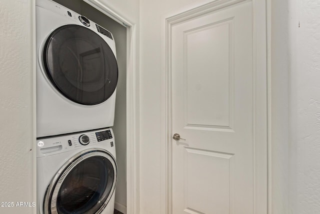 clothes washing area with stacked washing maching and dryer and laundry area