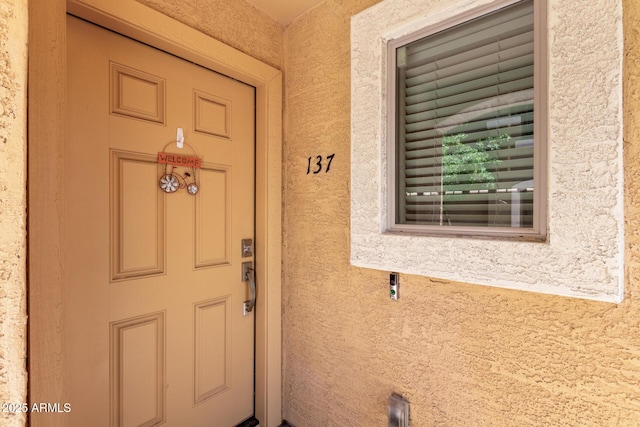 view of exterior entry featuring stucco siding