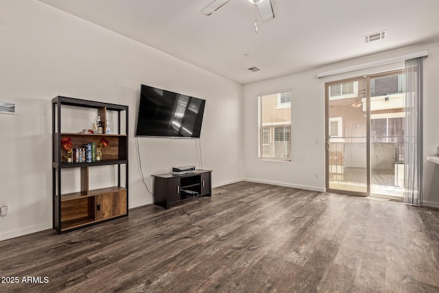 unfurnished living room featuring baseboards, a ceiling fan, dark wood-type flooring, and visible vents
