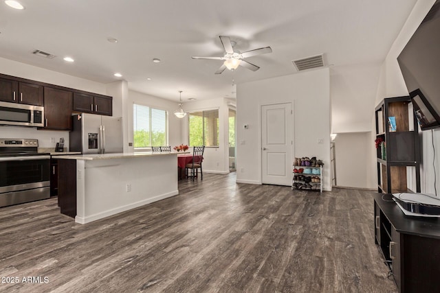 kitchen with dark brown cabinets, appliances with stainless steel finishes, a center island, a ceiling fan, and visible vents