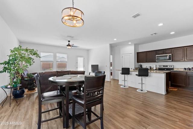 dining area featuring recessed lighting, visible vents, baseboards, light wood-style floors, and ceiling fan with notable chandelier