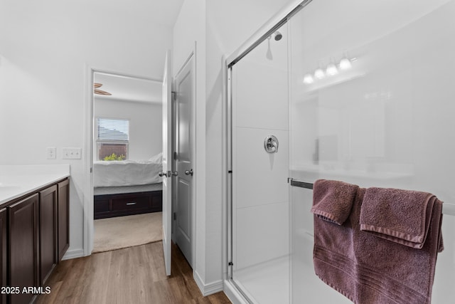 ensuite bathroom with wood finished floors, ensuite bath, vanity, and a shower stall