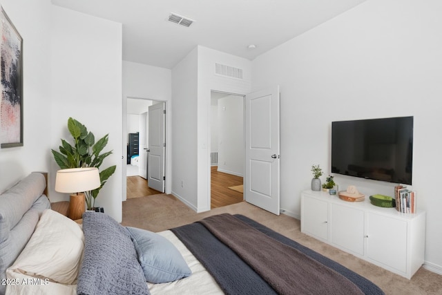 carpeted bedroom with visible vents and baseboards