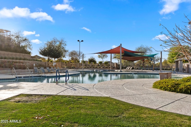 community pool featuring a patio, a yard, and fence