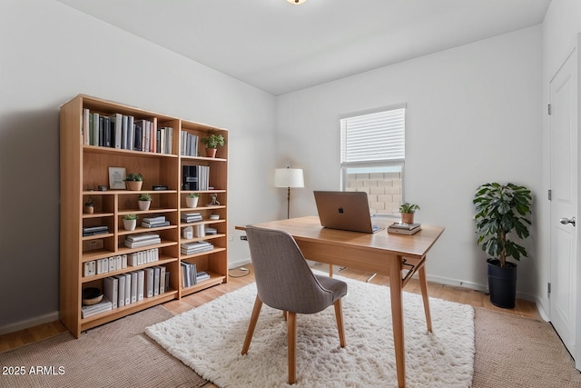 office with light wood-type flooring and baseboards