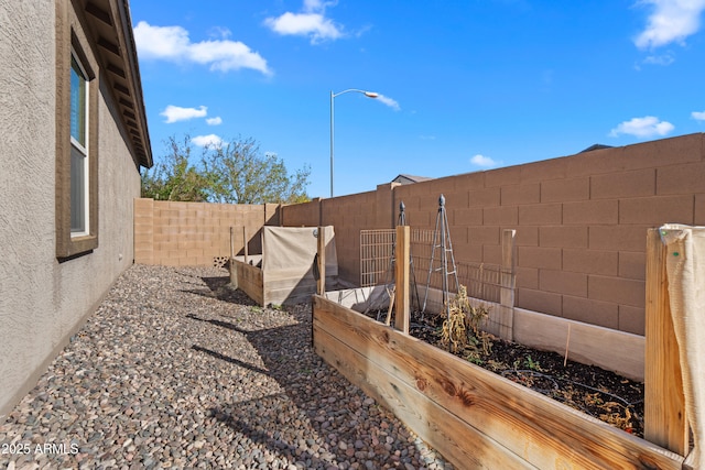 view of yard with a fenced backyard and a vegetable garden