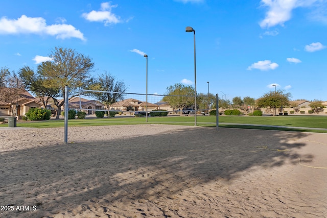 surrounding community with a residential view, a lawn, and volleyball court