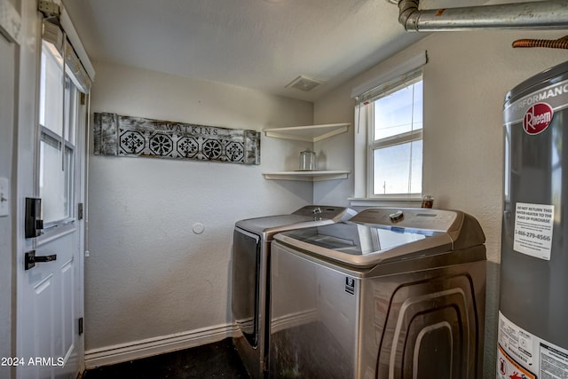 clothes washing area featuring washing machine and dryer and electric water heater