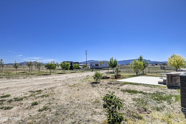 view of yard with a patio area, a mountain view, and a rural view