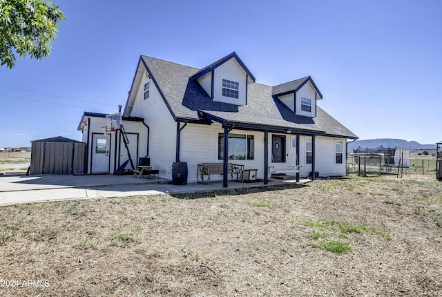 view of front facade with a storage unit and a patio