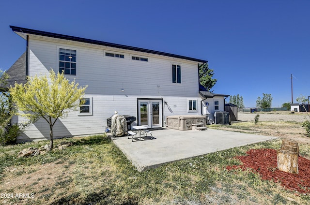 rear view of house with central air condition unit, french doors, and a patio