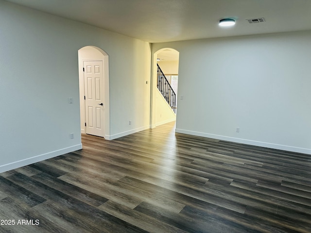 unfurnished room with dark wood-type flooring