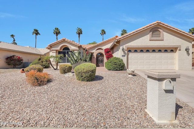 view of front of house with an attached garage, a tile roof, concrete driveway, and stucco siding