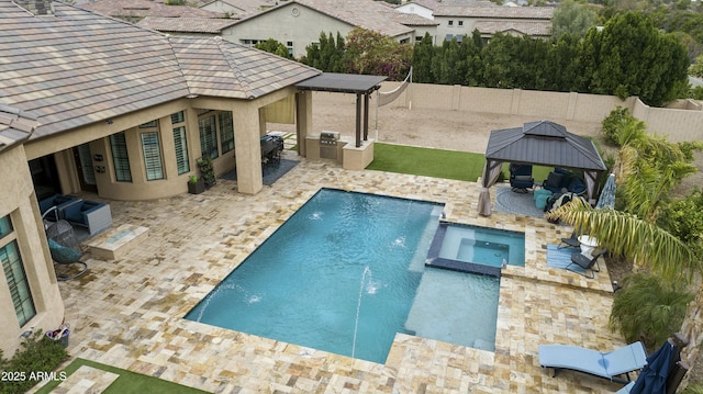 view of swimming pool featuring a pool with connected hot tub, a fenced backyard, a gazebo, exterior kitchen, and a patio area