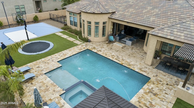 view of swimming pool featuring a lawn, outdoor dining space, a pool with connected hot tub, a fenced backyard, and a patio area