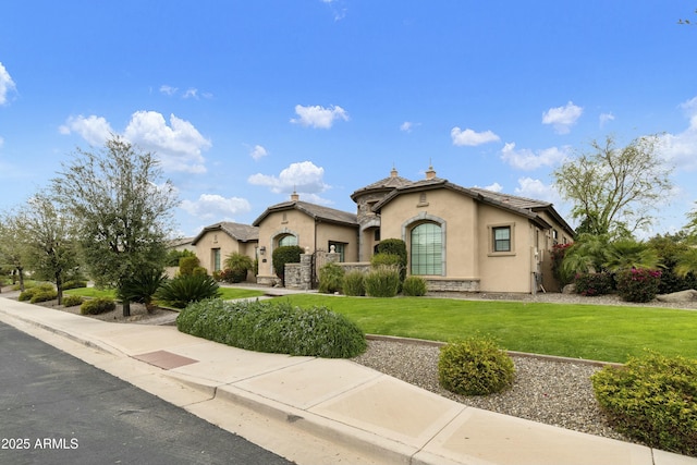 view of front of home with stone siding, stucco siding, a tiled roof, and a front yard