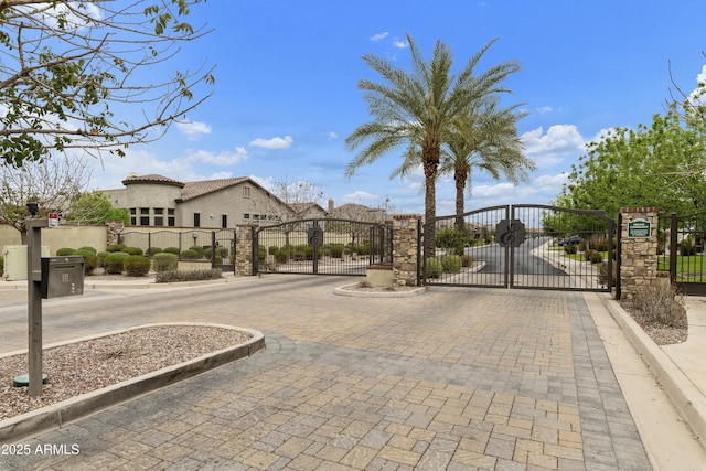 view of street featuring a gate, curbs, and a gated entry