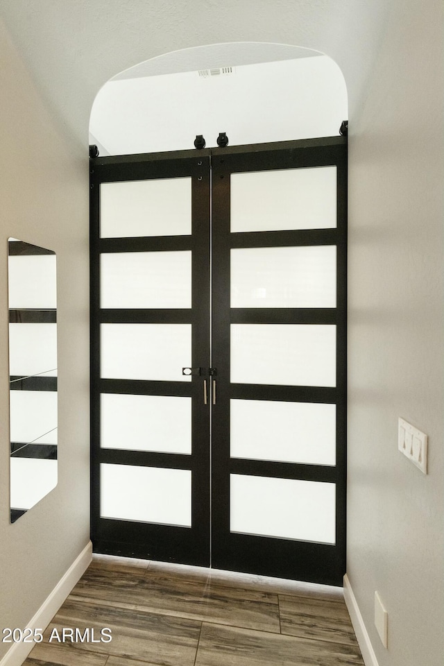 interior space with wood finished floors, french doors, and baseboards