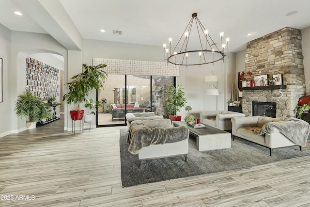 living room featuring visible vents, a notable chandelier, wood finished floors, recessed lighting, and a fireplace