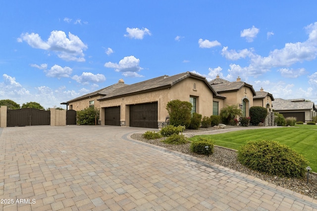 view of front of property with stucco siding, a gate, decorative driveway, a garage, and a chimney